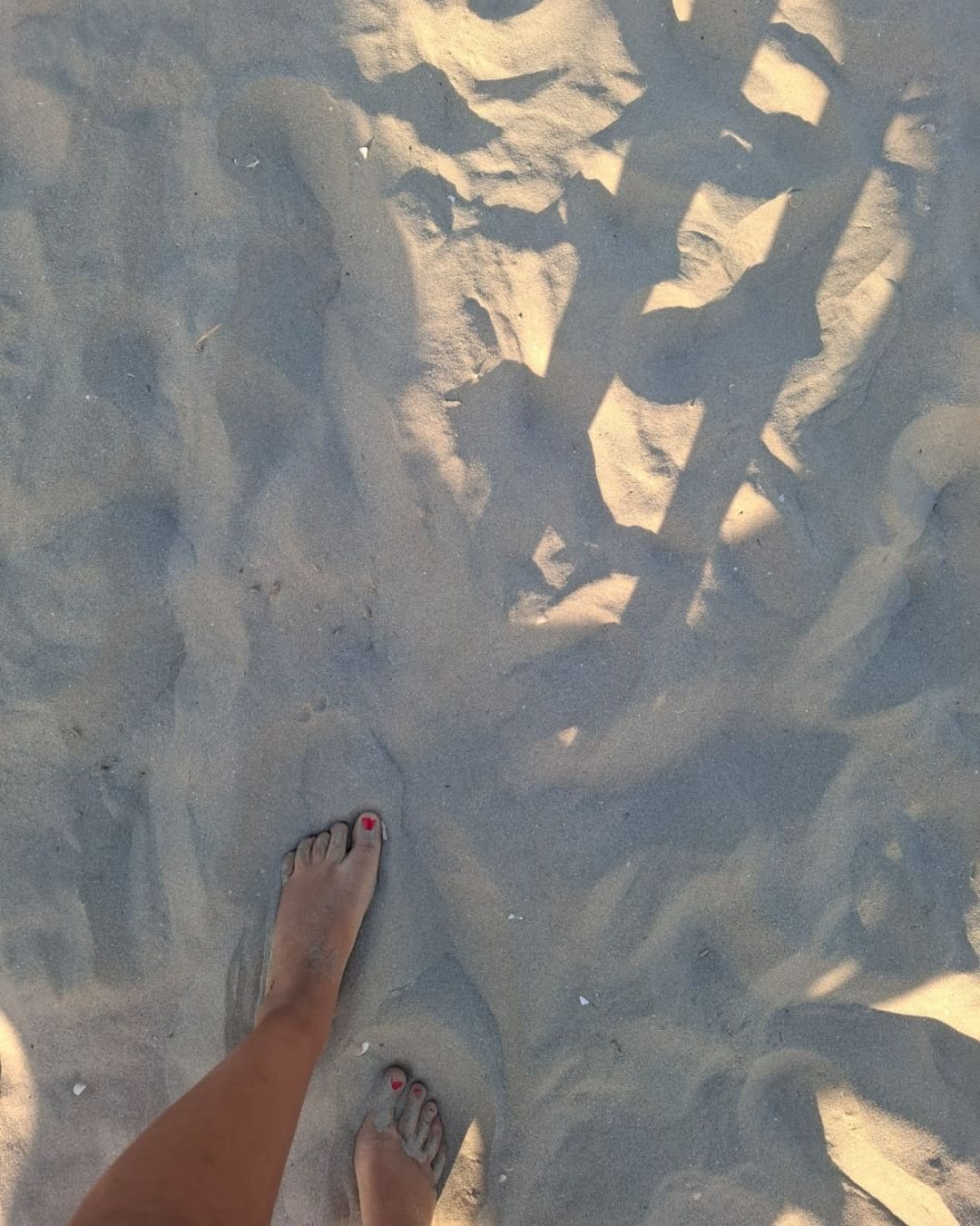 Piedi nudi sulla sabbia bagnata, sulla battigia di Cervia